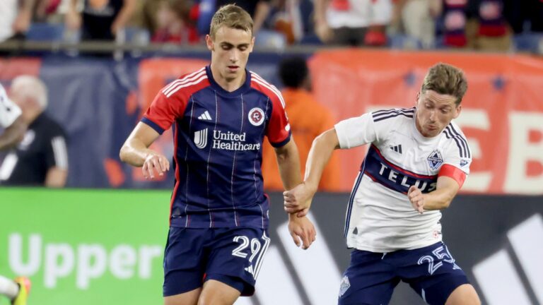 New England Revolution midfielder Noel Buck (29) and Vancouver Whitecaps midfielder Ryan Gauld (25) chase the ball during the second half of an MLS soccer match.