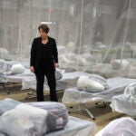 Massachusetts Governor Maura Healey pauses to look at the Army cots set up on the gym floor as State and local officials toured the Melnea A. Cass Recreational Complex on Jan. 31, 2024, in the Roxbury neighborhood of Boston. The facility will housed over 300 migrants.