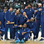 Gold medallists (From L) USA's #04 Stephen Curry, USA's #07 Kevin Durant, USA's #05 Anthony Edwards, USA's #09 Tyrese Haliburton, USA's #08 Derrick White, USA's #10 Jayson Tatum, USA's #06 LeBron James, USA's #11 Joel Embiid, USA's #13 Bam Adebayo, USA's #14 Anthony Davis, USA's #15 Devin Booker and USA's #12 Jrue Holiday pose on the podium after the men's Gold Medal basketball match between France and USA during the Paris 2024 Olympic Games at the Bercy Arena in Paris on August 10, 2024.