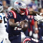 New England Patriots quarterback Joe Milton eludes a sack during the second half of a preseason NFL football game against the Carolina Panthers, Thursday, Aug. 8, 2024, in Foxborough, Mass.