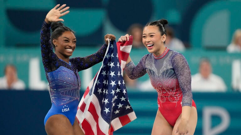 Simone Biles, left, celebrates with teammate Suni Lee, of the United States, after winning the gold and bronze medals respectively in the women's artistic gymnastics all-around finals in Bercy Arena at the 2024 Summer Olympics.