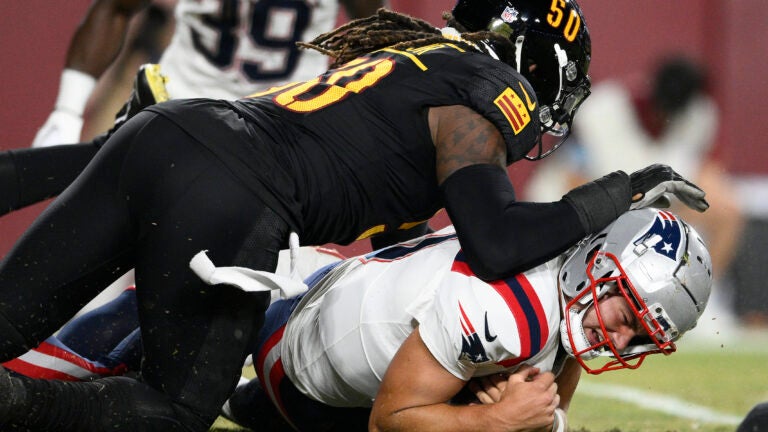 Drake Maye is tackled by Commanders defensive end Andre Jones Jr. during a preseason game after recovering his own fumble.