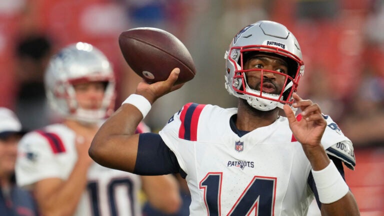 New England Patriots quarterbacks Jacoby Brissett (14) and Drake Maye (10) warm up before a preseason NFL football game against the Washington Commanders, Sunday, Aug. 25, 2024, in Landover, Md.