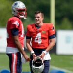 New England Patriots quarterbacks Jacoby Brissett and Bailey Zappe speak during an NFL football practice in Foxborough.