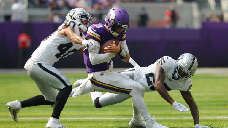 Minnesota Vikings quarterback J.J. McCarthy (9) is hit by Las Vegas Raiders safety Jaydon Grant (40) as he scramble for yards during the first half of an NFL football game.