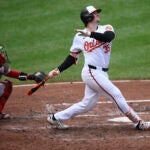 Baltimore's Adley Rutschman, right, watches his home run against the Red Sox during the fifth inning.