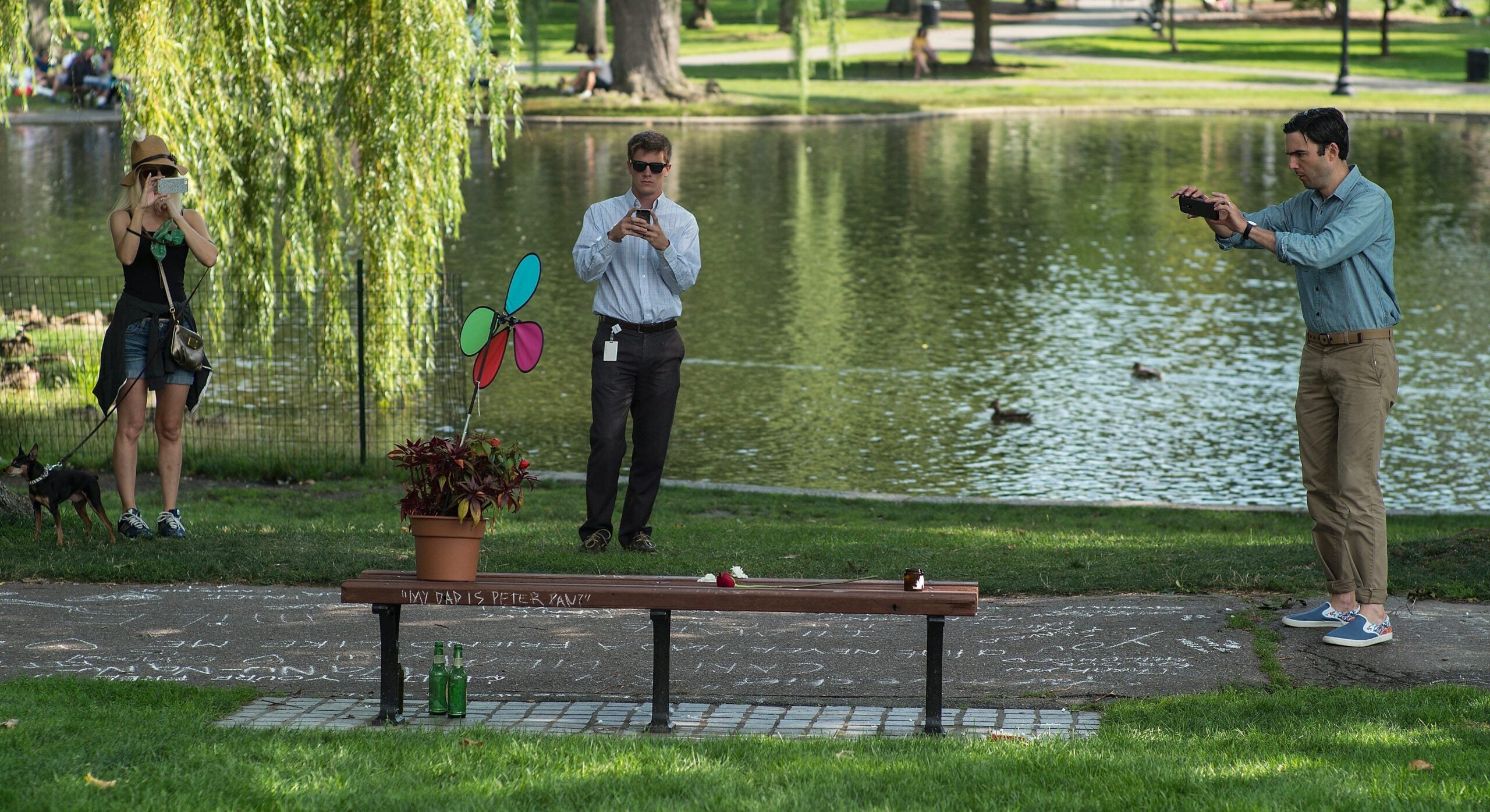 Visitors take photographs of the bench featured in the film "Good Will Hunting" on August 12, 2014, following news of the death of actor Robin Williams.