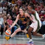 Indiana Fever's Caitlin Clark (22) goes to the basket against Seattle Storm's Jewell Loyd during the first half of a WNBA basketball game.
