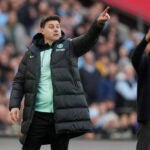 Chelsea's head coach Mauricio Pochettino, left, and Manchester City's head coach Pep Guardiola gesture during the English FA Cup semifinal soccer match between Manchester City and Chelsea at Wembley stadium in London.