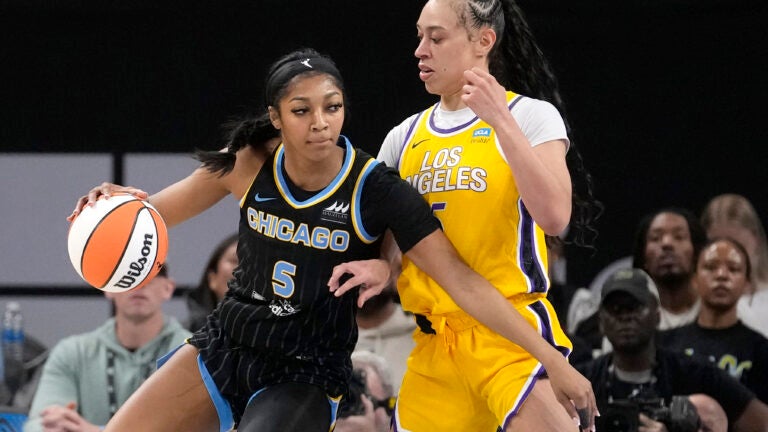 Chicago Sky's Angel Reese (5) drives to the basket as Los Angeles Sparks' Dearica Hamby defends during the first half of a WNBA basketball game.