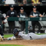 New York Yankees' Jazz Chisholm Jr., right, dives by Chicago White Sox catcher Korey Lee, left, to score on a single by Anthony Volpe during the fifth inning of a baseball game in Chicago.