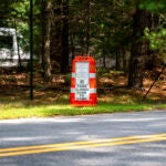 A sign alerts visitors that the park is closed from dusk to dawn because of the threat of eastern equine encephalitis at the entrance of Forges Field in Plymouth, Mass.