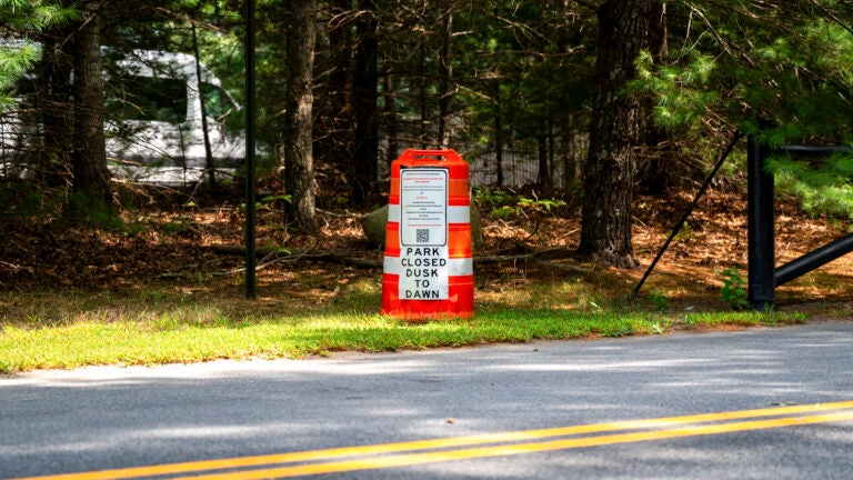 A sign alerts visitors that the park is closed from dusk to dawn because of the threat of eastern equine encephalitis at the entrance of Forges Field in Plymouth, Mass.