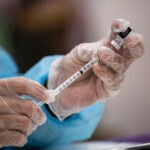 A healthcare worker prepares a dose of the Pfizer COVID vaccine at a clinic.