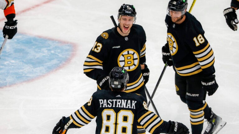 Boston Bruins center Charlie Coyle (18) celebrates his goal with teammates center Pavel Zacha (18) and right wing David Pastrnak (88) against the Anaheim Ducks during second period NHL action at TD Garden.