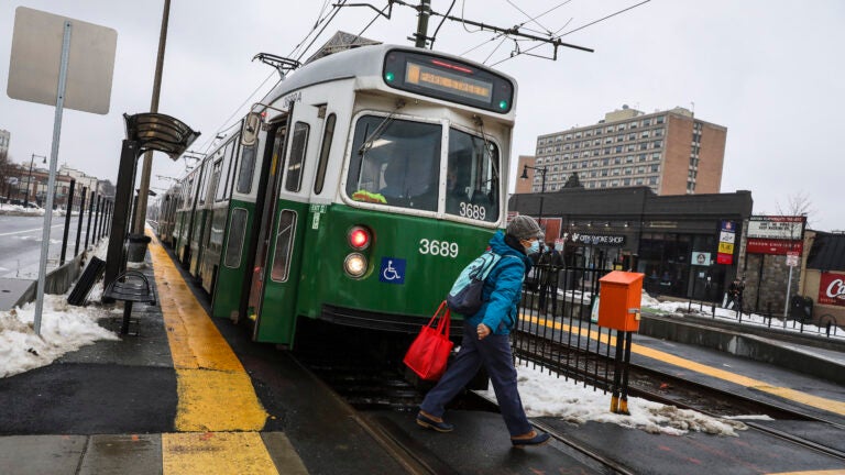 A person crosses in front of a Green Line B train.
