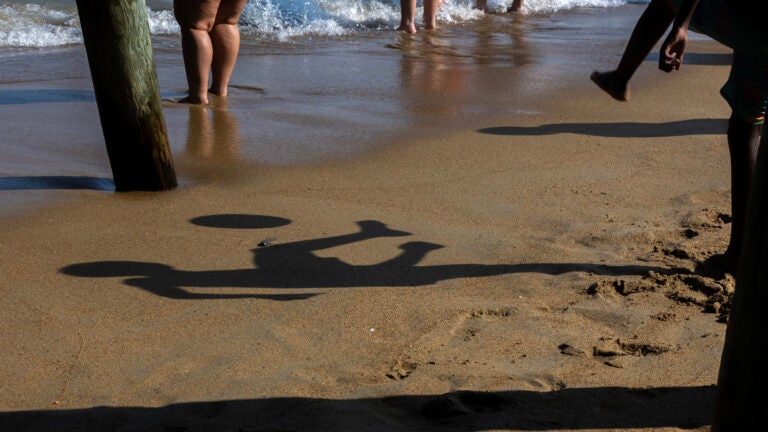 A boy plats soccer under the shadow of The Pier pillings at Old Orchard Beach in Maine.
