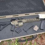 Police arrested two men after an AR style rifle and ammunition were found hidden in the woods on Friday.