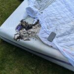 Firefighters removed burning bedding from a house due to a fire caused by a cell phone explosion.