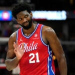 76ers' Joel Embiid waves to Bulls fans after hitting a 3-point shot in a game against the Bulls.
