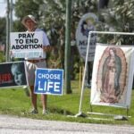 Dave Behrle, 70, of Safety Harbor holds a sign while standing outside the All Women's Health Center of Clearwater on May 3, 2022.