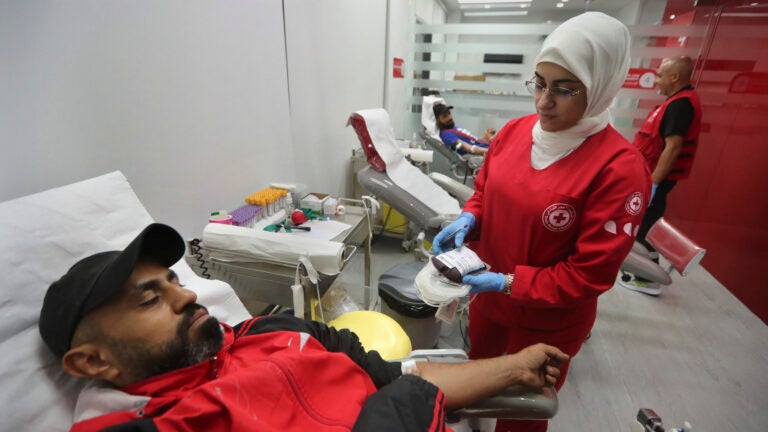 People donate blood for those who were injured by their exploded handheld pagers, at a Red Cross center, in the southern port city of Sidon, Lebanon.