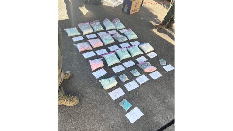 Seized counterfeit pills are displayed.