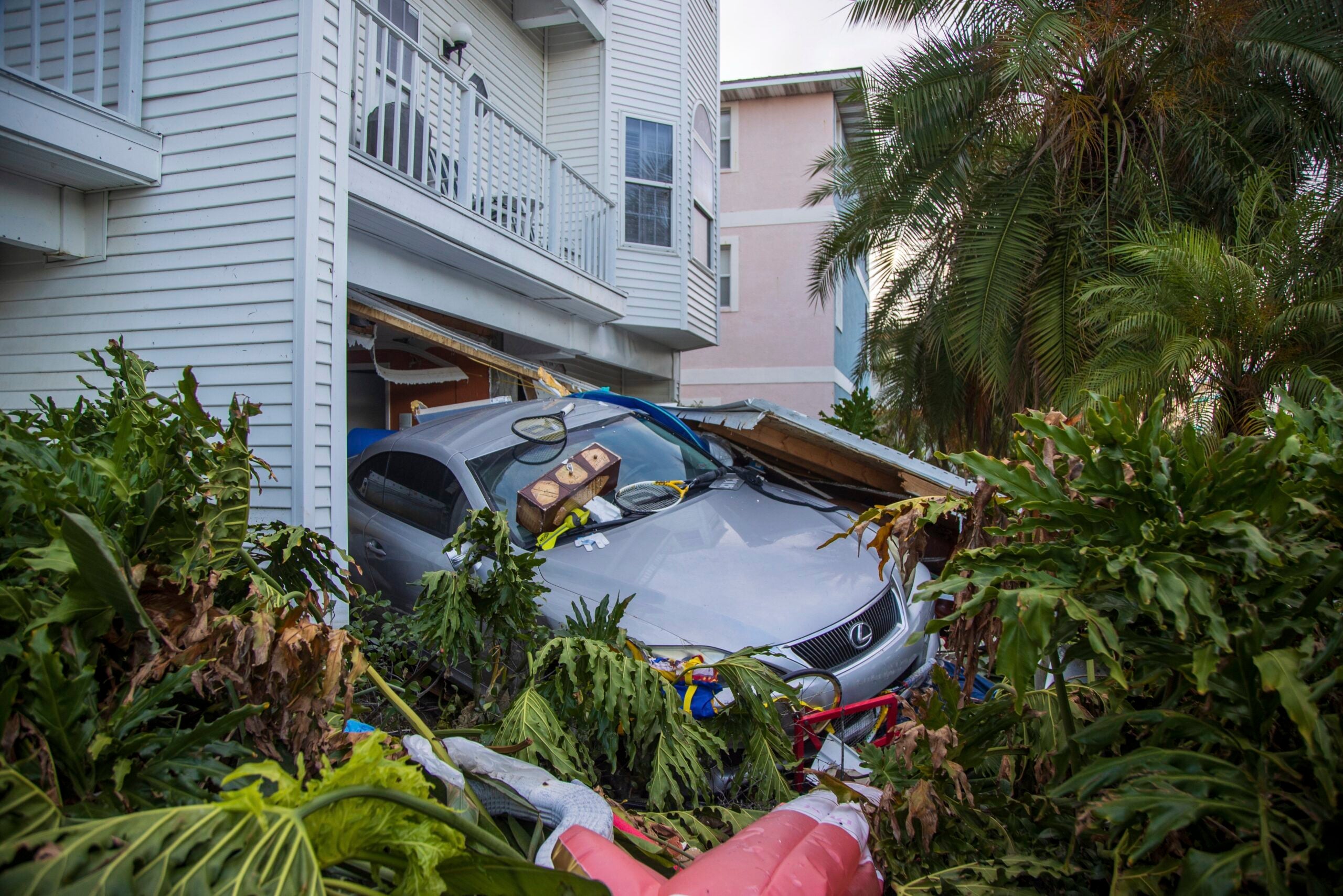 A vehicle sits outside of its garage after storm surge from Hurricane Helene. 