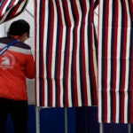 A voter enters a booth to fill out a ballot in a primary election to pick candidates for governor, the U.S. House, and the state Legislature.