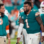 Dolphins coach Mike McDaniel talks to Tua Tagovailoa as he leaves the game after suffering a concussion during a game against the Bills.
