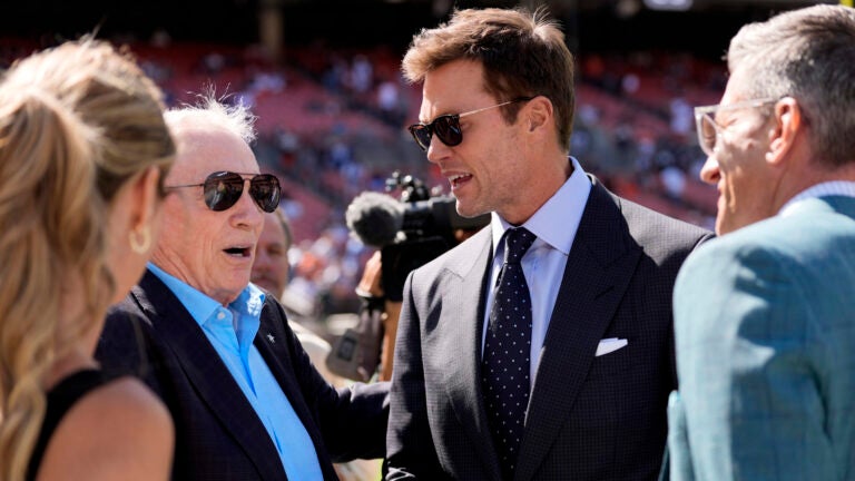 Tom Brady and Cowboys owner Jerry Jones talk with other players during the team's warmup before the game against the Browns.