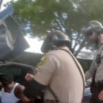 Police body camera video shows an officer dragging Dolphins wide receiver Tyreek Hill out of his sports car by his arm and head, then forcing him face first onto the ground after Hill put up his window.