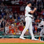 Red Sox pitcher Kutter Crawford prepares a fresh baseball as Baltimore Orioles' Cedric Mullins rounds the bases, on his two-run home run, during the third inning.