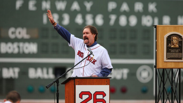 Wade Boggs waves to the fans in Fenway Park at the conclusion of the ceremony to retire his number 26. His Hall of Fame plaque is to his side.