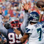 Seahawks quarterback Geno Smith throws an incomplete pass with pressure from Patriots Keion White during a Week 2 NFL game.