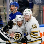 Boston Bruins left wing Brad Marchand (63) celebrates his empty net goal with teammate Charlie Coyle (13) as Toronto Maple Leafs center Calle Jarnkrok (19) looks at the replay on the scoreboard during third period action of the NHL Playoffs in game 3, of round 1, at Scotiabank Arena.