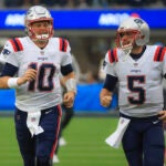 New England Patriots quarterbacks Mac Jones and Brian Hoyer running on to the field before they play the Los Angeles Chargers during NFL action at SoFi Stadium. (Matthew J Lee/Globe staff)