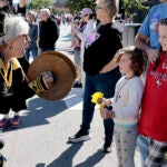 A band member of the Honk Fest Parade greets young spectators as they make their way towards Harvard Square.