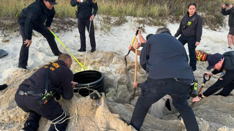 Emergency crews rescue a child trapped in a sinkhole on Cape Beach