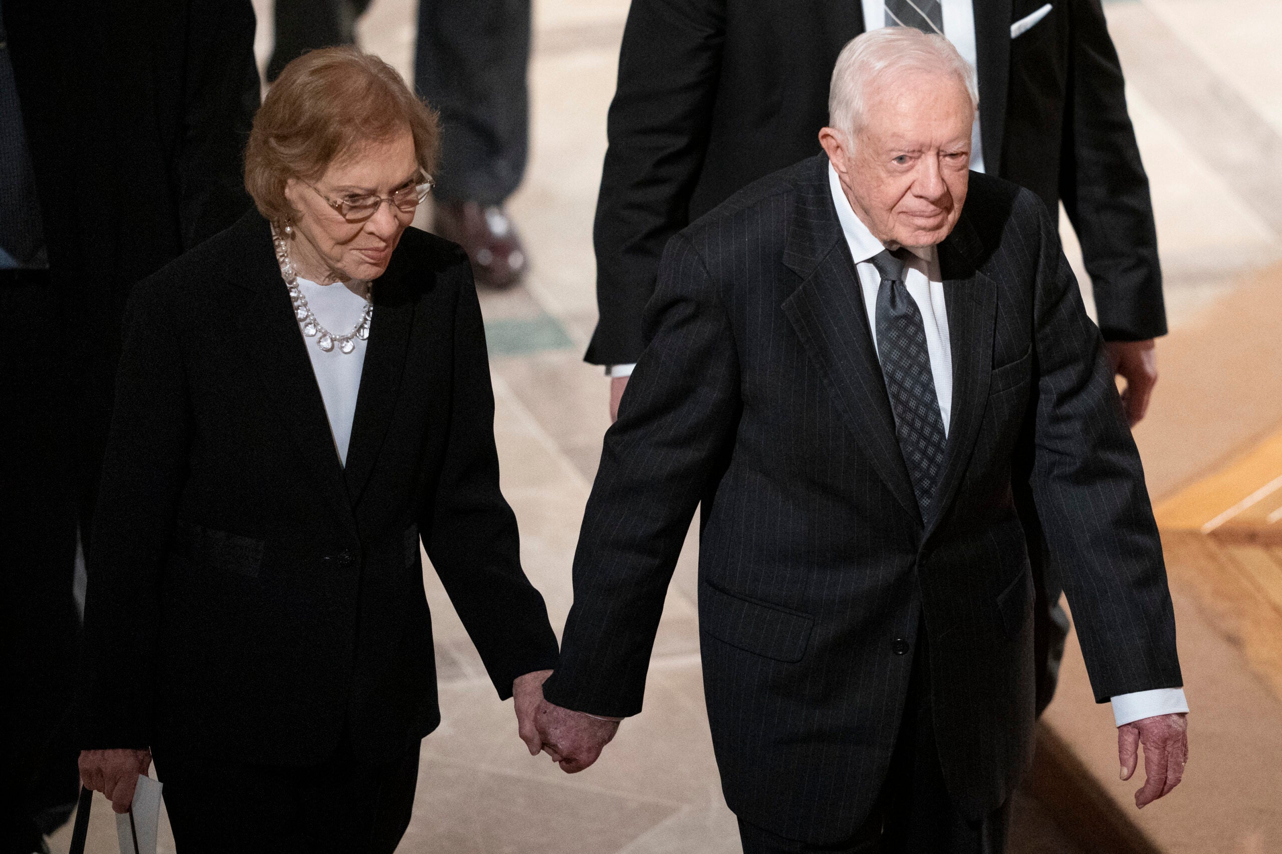 Former President Jimmy Carter, right, and his wife, former first lady Rosalynn Carter, hold hands in 2018. 