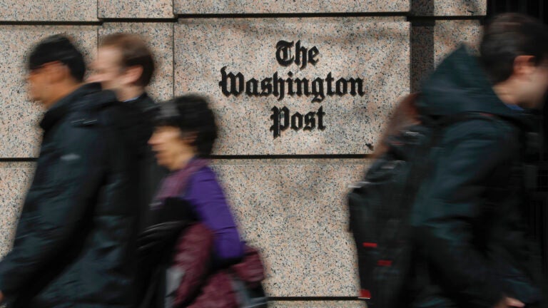 People walk by the One Franklin Square Building, home of The Washington Post newspaper, in downtown Washington.