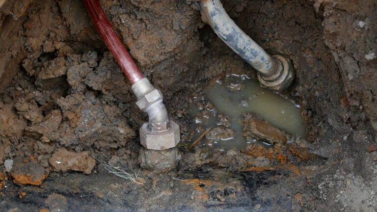 A copper water supply line, left, is shown connected to a water main after being installed for lead pipe, right, July 20, 2018, in Flint, Mich.