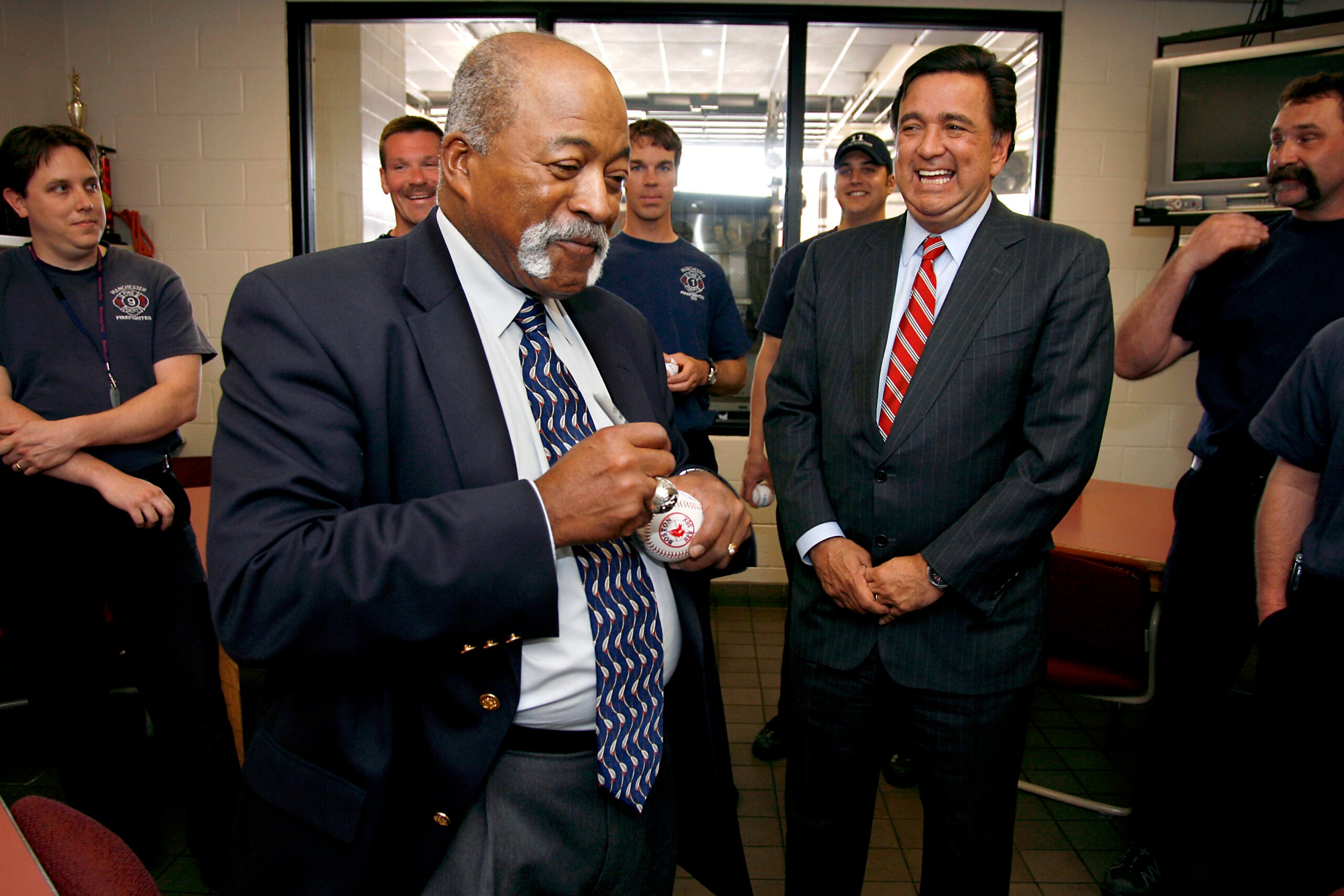 Former major league baseball player Luis Tiant signs baseballs for firefighters at the Manchester Fire Department in Manchester, N.H.