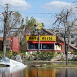 A billboard lies atop a Waffle House restaurant after being knocked down by Hurricane Michael in Panama City, Fla.