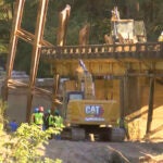 This image taken from video from WLBT shows construction workers at the scene after a bridge over the Strong River on State Route 149 in Simpson County, Miss., collapsed on Wednesday, Oct. 16, 2024.