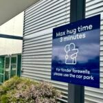A sign informing time limits for visitors to the passenger drop-off area outside Dunedin Airport in Momona, New Zealand.