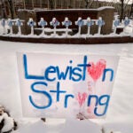 Snow coats crosses at one of several memorials for the victims of the mass shooting in Lewiston, Maine.