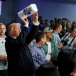 President Donald Trump tosses paper towels into a crowd at Calvary Chapel in Guaynabo, Puerto Rico.