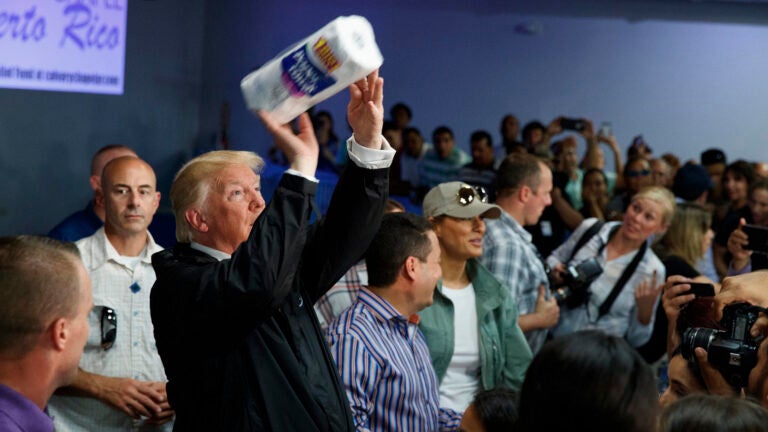President Donald Trump tosses paper towels into a crowd at Calvary Chapel in Guaynabo, Puerto Rico.