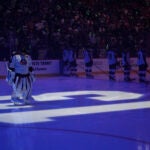 Blue Jackets goaltender Elvis Merzlikins stands on a No. 13 on the ice honoring Johnny Gaudreau and his brother Matthew.